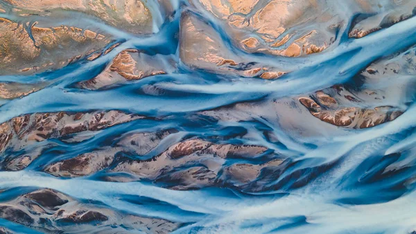 A glacial rivers from above. Aerial photograph of the river streams from Icelandic glaciers. Beautiful art of the Mother nature created in Iceland. Wallpaper background high quality photo