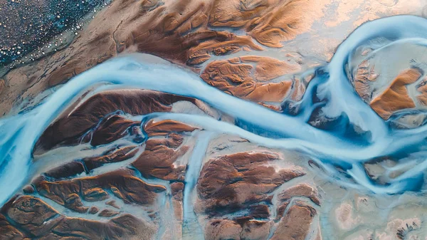 Yukarıdan bir buzul nehri. Nehrin havadan çekilmiş fotoğrafı İzlanda buzullarından geliyor. İzlanda 'da yaratılan doğa ananın güzel sanatı. Duvar kağıdı arka plan yüksek kaliteli fotoğraf