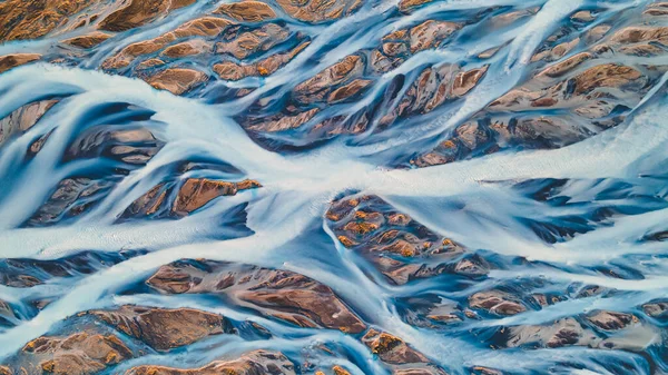 Yukarıdan bir buzul nehri. Nehrin havadan çekilmiş fotoğrafı İzlanda buzullarından geliyor. İzlanda 'da yaratılan doğa ananın güzel sanatı. Duvar kağıdı arka plan yüksek kaliteli fotoğraf