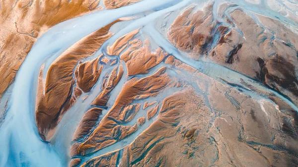 Yukarıdan bir buzul nehri. Nehrin havadan çekilmiş fotoğrafı İzlanda buzullarından geliyor. İzlanda 'da yaratılan doğa ananın güzel sanatı. Duvar kağıdı arka plan yüksek kaliteli fotoğraf