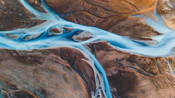 Yukarıdan bir buzul nehri. Nehrin havadan çekilmiş fotoğrafı İzlanda buzullarından geliyor. İzlanda 'da yaratılan doğa ananın güzel sanatı. Duvar kağıdı arka plan yüksek kaliteli fotoğraf