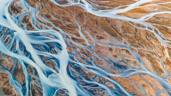 Yukarıdan bir buzul nehri. Nehrin havadan çekilmiş fotoğrafı İzlanda buzullarından geliyor. İzlanda 'da yaratılan doğa ananın güzel sanatı. Duvar kağıdı arka plan yüksek kaliteli fotoğraf