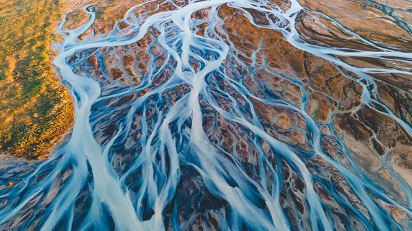 Yukarıdan bir buzul nehri. Nehrin havadan çekilmiş fotoğrafı İzlanda buzullarından geliyor. İzlanda 'da yaratılan doğa ananın güzel sanatı. Duvar kağıdı arka plan yüksek kaliteli fotoğraf