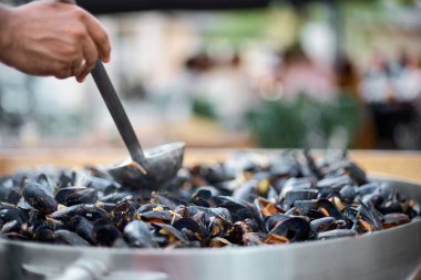 Midye hazırlanması. Bir tavada midye. Sokak gıda, sıcak. seçici odak, kopya alanı.