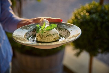 Zeytinyağı ve taze fesleğen, burrata peynirli taze İtalyan peynir mozzarella ve krem yapılmış.