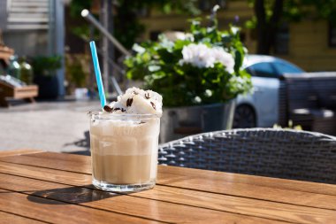 Dikey atış, bardak buzlu kahve, ahşap bir masa. buz ile seçici odak