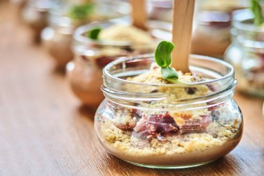 Ahşap masa üzerinde cam kavanozlara lezzetli meze servis. Kavramı için Catering, seçici odaklı