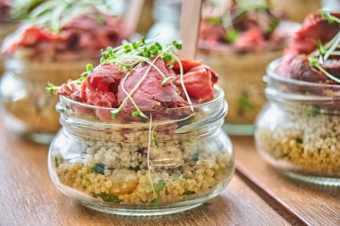 Ahşap masa üzerinde cam kavanozlara lezzetli meze servis. Kavramı için Catering, seçici odaklı