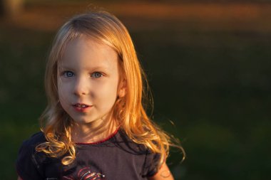 Sonbahar sonbahar parkta duran, kameraya, mutlu yaşam tarzı çocukluk kavramı seyir portre portre sevimli tatlı gülümseyen, küçük sarışın kız