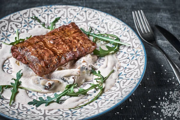 Concept: restaurant menu, healthy food, homemade, gourmet, gluttony. plate with steak and mushroom sauce on a weathered wooden table. Top down view. Close-up.