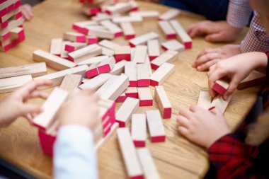 Çocuk ahşap çubukları kulede çalış. Kat ahşap parçaları. Çocuk kulenin katları çubuklardan dışarı alır. Tahta oyunu. Öğrenme ve eğitim kavramı. Üstten görünüm