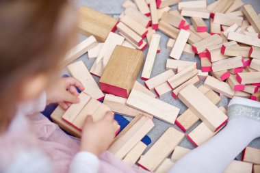Çocuk ahşap çubukları kulede çalış. Kat ahşap parçaları. Çocuk kulenin katları çubuklardan dışarı alır. Tahta oyunu. Öğrenme ve eğitim kavramı. Üstten görünüm