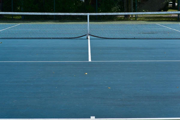 Теннисные корты с синей поверхностью и сеткой — стоковое фото