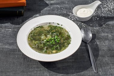 Yaz menüsü. Yeşil yumurta ile kuzukulağı çorbası. Geleneksel Rus çorbası, kuzukulağı, yeşil bezelye ve yumurta. eski ahşap arka plan, seçici odak