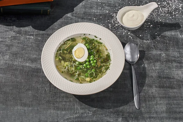 Yaz menüsü. Yeşil yumurta ile kuzukulağı çorbası. Geleneksel Rus çorbası, kuzukulağı, yeşil bezelye ve yumurta. eski ahşap arka plan, seçici odak
