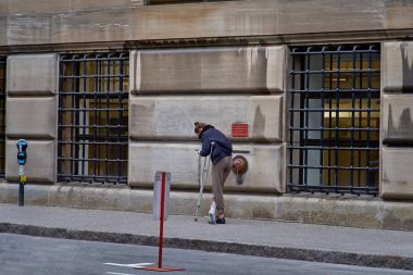 Montreal, Quebec, Kanada, 29 Eylül, 2018: sokakta koltuk değneği üzerinde genç adam Montreal şehir merkezinde bir telefonda bir mesaj görmek için durdu.