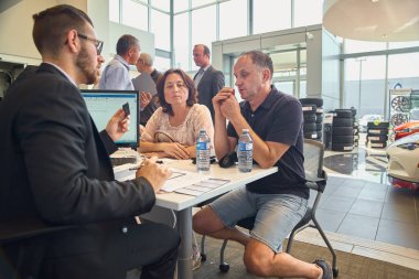 Montreal, Quebec, Kanada 31 Ağustos 2018: genç erkek danışman ve alıcılar Auto Show 'da yeni araba için sözleşme imzalama. Mazda Auto Shop, Montreal, Kanada.