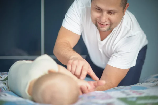 young dad holds the hand of his newborn baby. Hand in hand. Little baby hand in dad s big hands. Together love family nursery healthcare and medical father s day concept