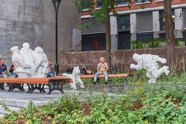 Montreal, Kanada - 3 Eylül 2018: Montreal, Kanada'daki Place de Arm'daki Parc de la Presse heykeli. Evsizinsanlar bir bankta oturmuş uyuyorlar..