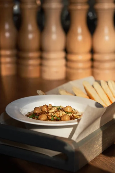 Традиційні середземноморські закуски. Хумус з кедровими горіхами, оливковою олією, подається на тарілку з Лаваш хліб, подається в ресторані. Сонячне світло, освітлену від вікна, низький ключ — стокове фото