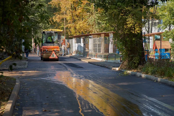 Chisinau, Moldova, 25 Mart 2019: Yeni yol inşaatında yeni asfalt yol inşa etme sürecini işleyen işçi