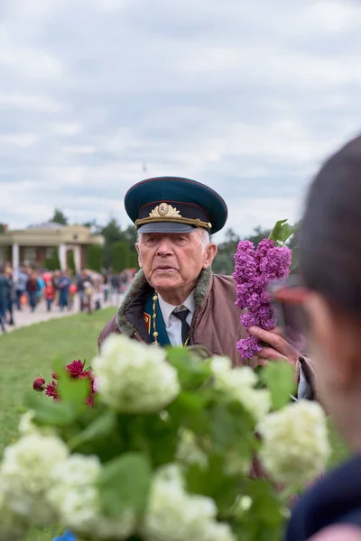 Chisinau, Moldavia, 9 de mayo de 2019: veterano de guerra recibe felicitaciones por el Día de la Victoria. Niños con padres regalan flores celebra el 74 aniversario de la Victoria — Foto de Stock