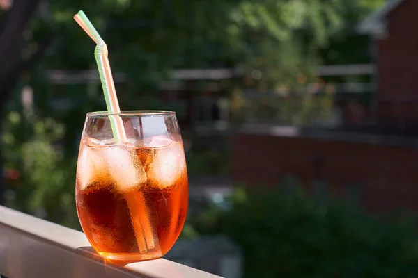 Cocktail glass aperol on the railing of the balcony of the house. Lifestyle concept, space for text. — Stock Photo, Image