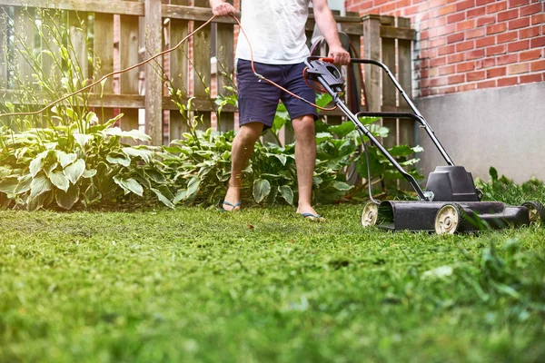 De grasmaaier is oud in een prive-huis, maaien van het gras, apparaten, maaien, tuinman, zorg, werk, gereedschap — Stockfoto