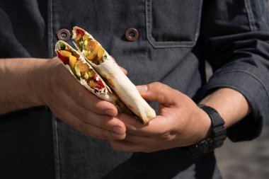 Shawarma - en iyi sokak gıda . Doğu mutfağı. Et ve sebze - lezzetli ve sağlıklı . Bir adamın ellerinin yakın çekim.