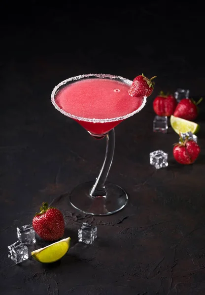 Copo de delicioso daiquiri de morango com limão e cubos de gelo sobre fundo preto — Fotografia de Stock