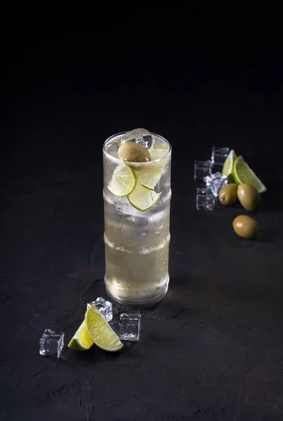 Koktejl s ginem, Pesleym, citronem, olivou a rozdrceným ledem na tmavém pozadí. Koktejlová karta — Stock fotografie