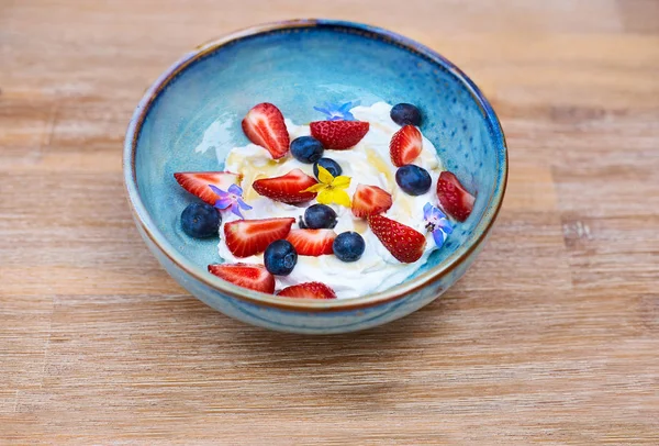 Az egészséges reggeli. Friss gyümölcs, Blueberry bogyók joghurttal. Reggel reggeli egy kék tányéron az asztalon. — Stock Fotó