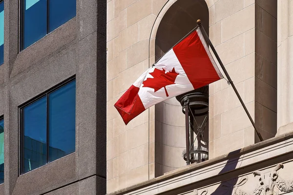 Bandera de Gran Canadá ondeando en el viento con una pared en el fondo —  Fotos de Stock