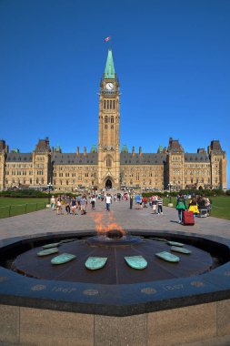 Ottawa, Ontario, Kanada 18 Eylül 2018: Merkez bloğun arka planına ve Parlamento Tepesi'ndeki Barış Kulesi'ne karşı yüzyıllık flam ve turistler, Ottawa, Kanada.