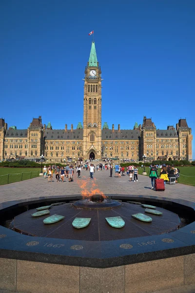 Ottawa, Ontario, Kanada 18 Eylül 2018: Merkez bloğun arka planına ve Parlamento Tepesi'ndeki Barış Kulesi'ne karşı yüzyıllık flam ve turistler, Ottawa, Kanada.