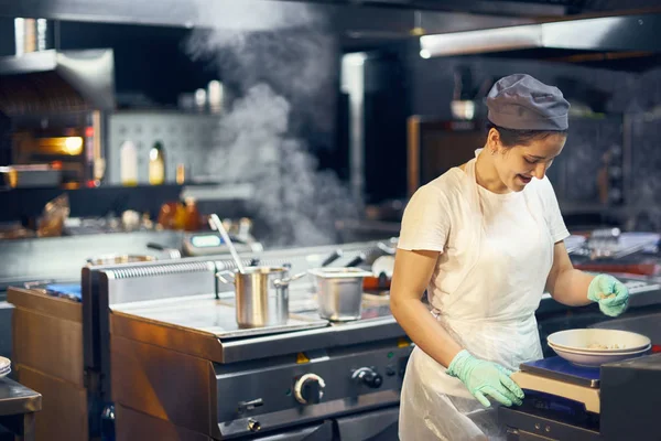 Mujer cocinar en el trabajo en una cocina moderna, flujo de trabajo de la cocina en una cocina., Copiar el espacio para el texto — Foto de Stock