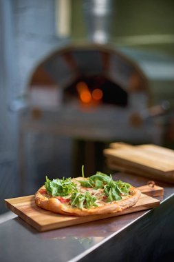 Fırıncı fırından taze pişmiş focaccia alır, kabuğu üzerinde. fırında et ve peynir ile İtalyan focaccia kavurma
