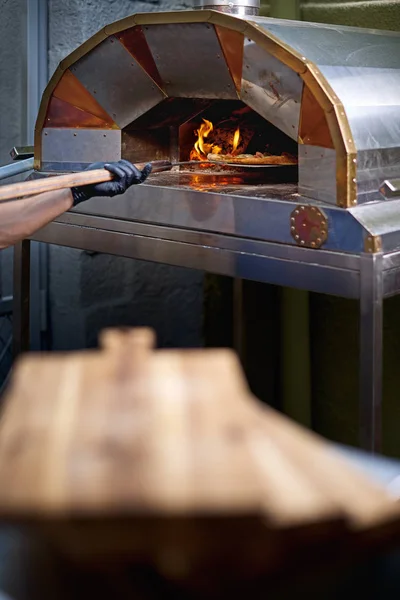 El panadero muestra una focaccia recién horneada, en la cáscara . — Foto de Stock