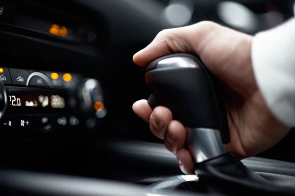 Engrenagem de comutação do homem, segurando o punho do carro moderno, vista close-up — Fotografia de Stock