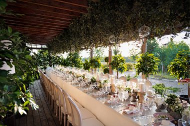 Bir restoranda açık hava düğün kutlama. Ayarlama, catering Festival tablo. Rustik tarzı düğün yaz, bir masada güzel küçük buketleri.