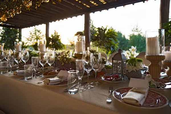 Celebrazione di nozze all'aperto in un ristorante. Apparecchiatura della tavola festiva, catering. Matrimonio in stile rustico in estate, bellissimi mazzi di fiori su un tavolo . — Foto Stock