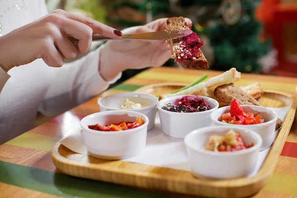 kız çeşitli aperatifler, vejetaryen gıda patlıcan kırmızı biber ve fasulye rustik ahşap masada pişmiş yiyor. Geleneksel Rus veya Moldavya, Romen veya Ukrayna yemekleri