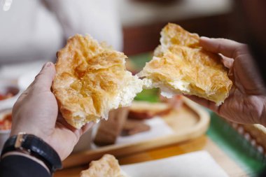 süzme peynirli salatalıklı turta ile ellerin yakın çekim. Adam tadına bakıyor. Break kavramı.