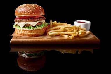 Zanaat sığır eti hamburger ve patates kızartması, siyah arka plan üzerine izole sos.