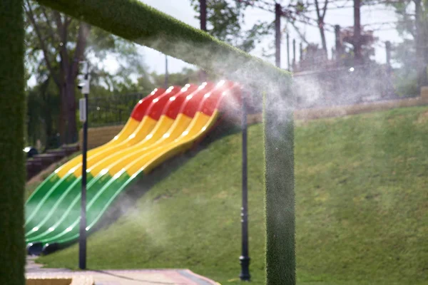 Luftkonditionering utomhus klimat i varmt väder. Gatugrindens klimatkontroll i vattenparken. Aerosol sprutning vattenstrålar, sprutning kylvatten. Luftkonditioneringsmunstycke — Stockfoto