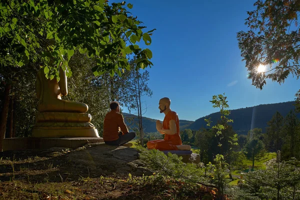 Ein 30-jähriger Mann in Lotusposition sitzt im Freien in der Nähe der Buddha-Statue in Quebec Harrington. Reise nach Kanada — Stockfoto