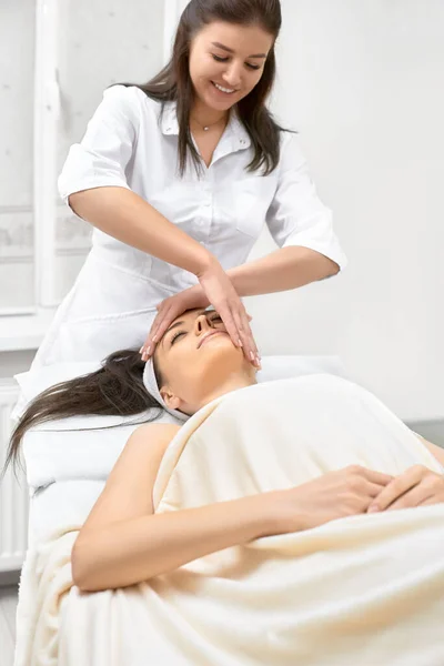 Spa, resort, beleza e conceito de saúde - mulher bonita no salão de spa recebendo tratamento facial — Fotografia de Stock
