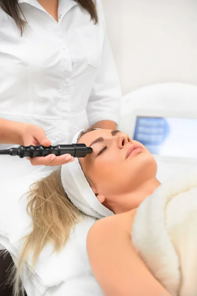 Zbliżenie kobieta z bliska otrzymywać elektryczne oczy masaż na mikrodermabrazji sprzęt w salon piękności. — Zdjęcie stockowe