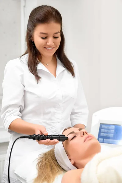 Cosmetologia hardware. Primo piano immagine di felice giovane donna con gli occhi chiusi ottenere procedura di sollevamento rf in un salone di bellezza — Foto Stock