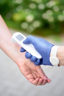 Restorandaki sıcaklık ölçümü için erkeklerin ellerinde vücut termometresi. Seçici odaklanma. Coronavirus önleme Corona virüsü salgını sırasında bir kafe restoranında ve yeni normal salgın konsepti